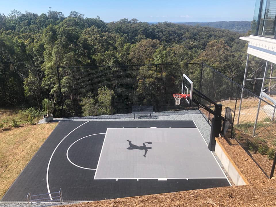 Half court basketball court next to a forest | Featured Image for the Backyard Basketball Court landing page.