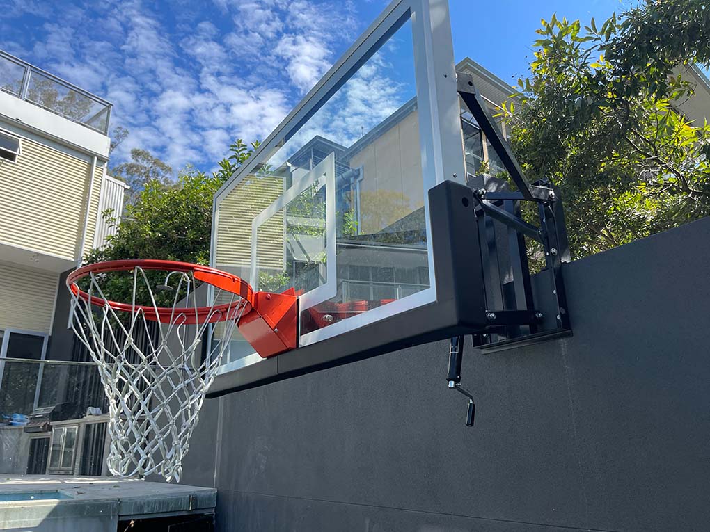 2 men installing a basketball post in a backyard