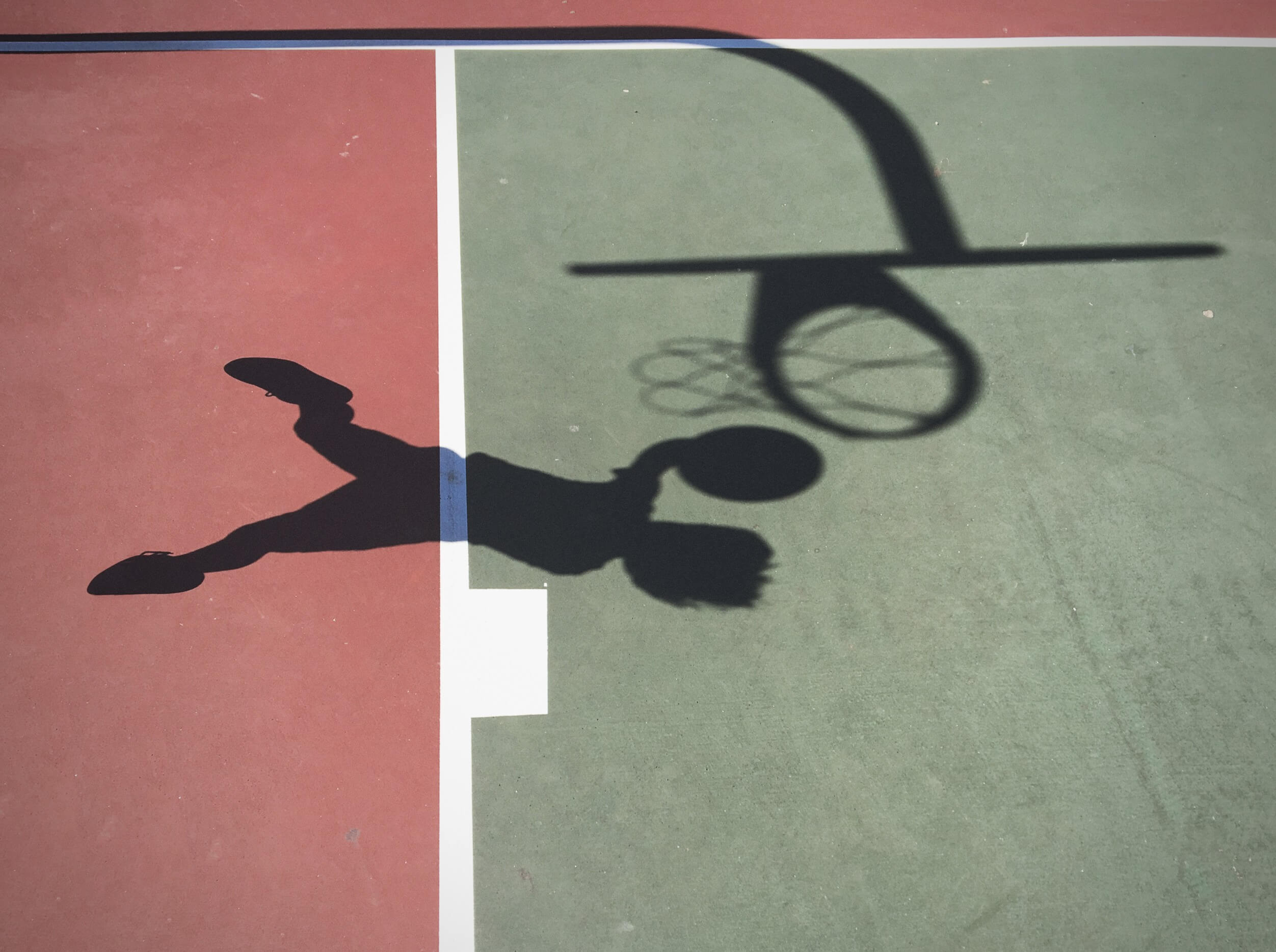 Shadow of boy jumping to play basketball | Featured Image for the Basketball Flooring blog